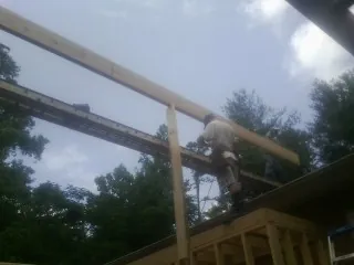 Carpenter setting a ridge beam over a new addition frame — Ice Dam Removal by Roofing Brothers in West Dennis