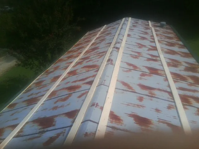 Rusted metal roof panels with new wood purlins before replacement — Storm Damage Roof Repair in West Dennis by Roofing Brothers
