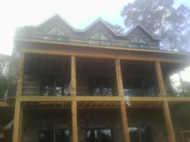 Dormers and porch framing on a large log home under construction — Roof Coating work by our crew in West Dennis