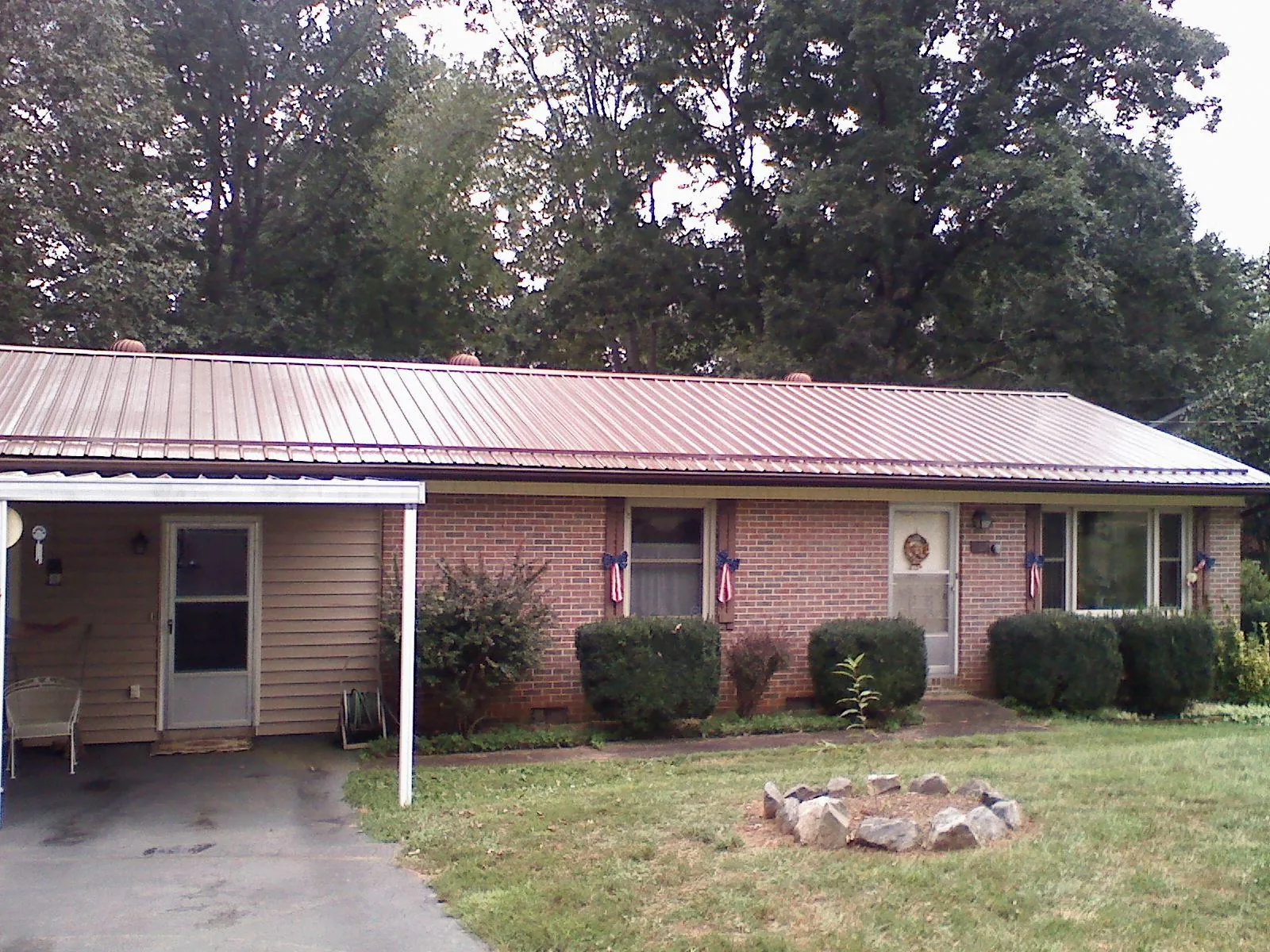 Bronze metal roof and carport on a brick ranch home — Roof Repair work by our crew in West Dennis